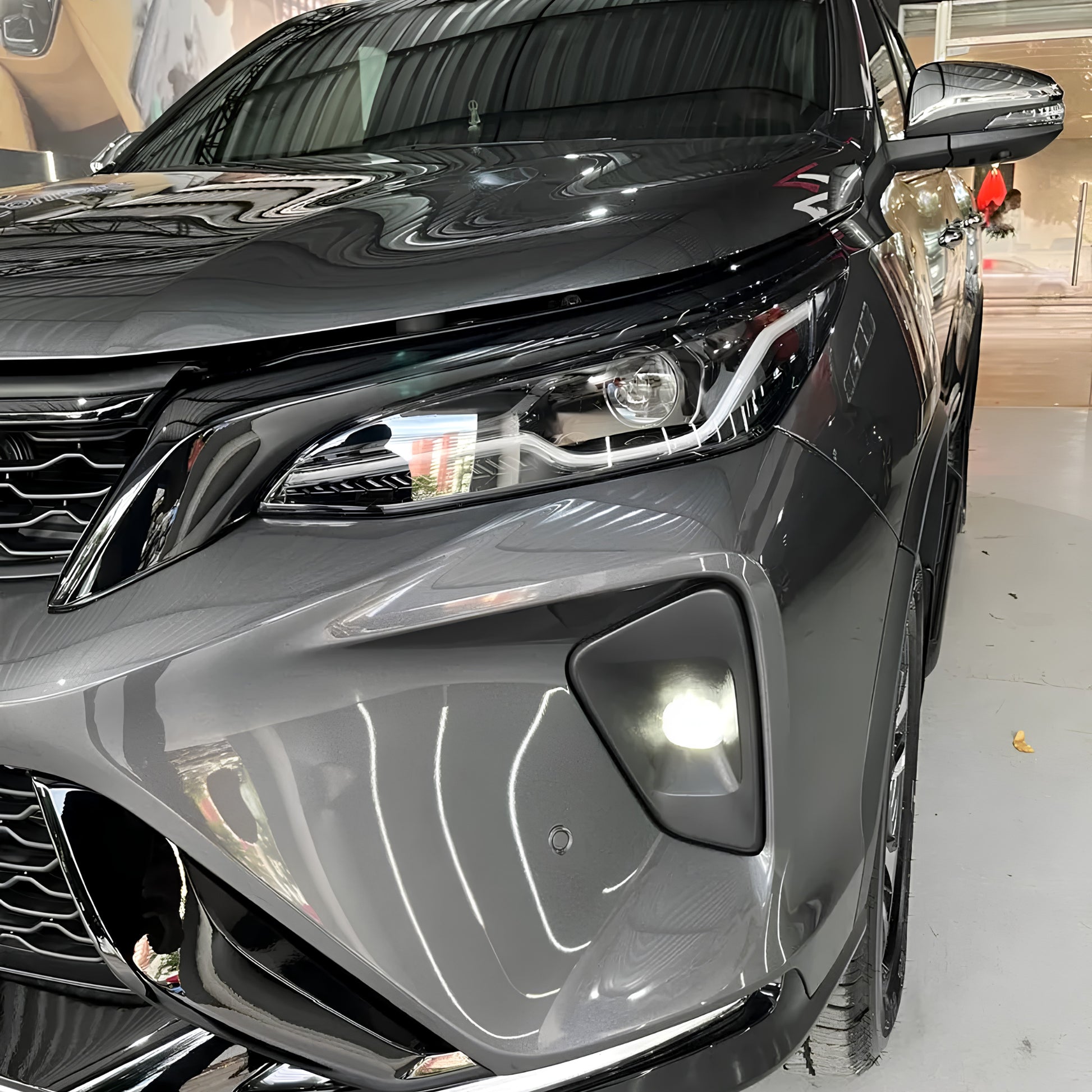 frontal da Toyota SW4 Platinum 2026 com farol, DRL e farol de neblina acesos, acabamento premium e visual moderno após transformação da SW4.